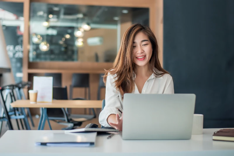 Charming asian businesswoman sitting working on laptop in office.